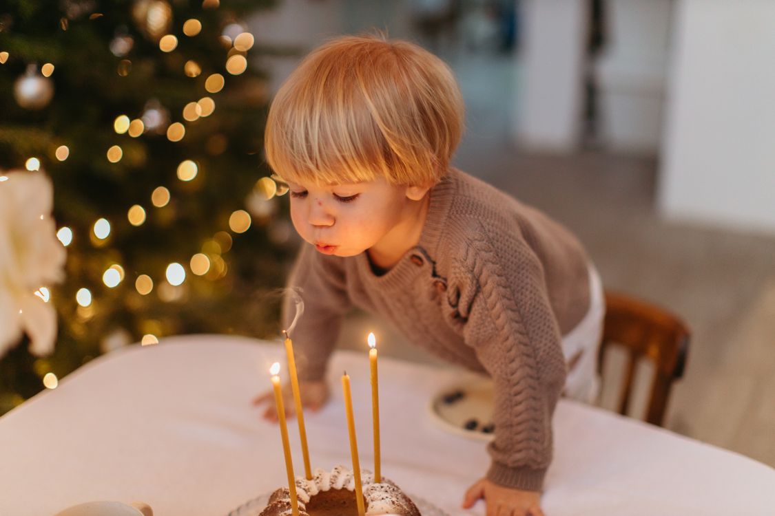 Ett barn som blåser ut ljusen på en födelsedagstårta